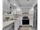 A modern kitchen features stainless steel appliances, white cabinets, and light countertops at 1442 Barton Place Dr, Raleigh, NC 27608