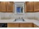 Close-up of the kitchen sink with oak cabinets and laminate countertops at 1442 Barton Place Dr, Raleigh, NC 27608