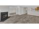 Comfortable living room with a fireplace, full-length mirror, and an opening to the kitchen area at 1442 Barton Place Dr, Raleigh, NC 27608