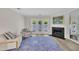 A living room with a fireplace and access to the outdoors features neutral furniture and a blue area rug at 1442 Barton Place Dr, Raleigh, NC 27608