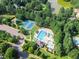 Aerial view of community pool, tennis courts, playground and parking, all surrounded by lush green trees and residential homes at 145 Ryder Cup Cir, Raleigh, NC 27603