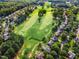 A lush golf course in a residential area is shown in this aerial shot, bordered by mature trees and well-manicured lawns at 145 Ryder Cup Cir, Raleigh, NC 27603