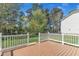 A deck overlooks the well-manicured backyard of this home, complete with an iron fence and mature landscaping at 145 Ryder Cup Cir, Raleigh, NC 27603