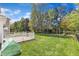 The backyard featuring a well-maintained lawn, a wood deck, a plastic greenhouse and a black metal fence at 145 Ryder Cup Cir, Raleigh, NC 27603