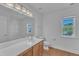 Bright bathroom featuring wood flooring, a large mirror, and vanity with wood cabinets at 145 Ryder Cup Cir, Raleigh, NC 27603
