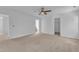 Spacious bedroom with neutral carpet, ceiling fan, and several doorways leading to other rooms at 145 Ryder Cup Cir, Raleigh, NC 27603