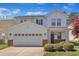 Charming two-story home with a well-manicured front lawn and a two-car garage on a sunny day at 145 Ryder Cup Cir, Raleigh, NC 27603