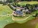 Aerial view of a golf course and clubhouse next to a lake surrounded by mature trees and lush fairways at 145 Ryder Cup Cir, Raleigh, NC 27603