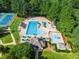 Aerial view of a neighborhood pool with a tennis court surrounded by lush greenery, offering recreational amenities at 145 Ryder Cup Cir, Raleigh, NC 27603