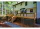 The backyard of the house features a wooden deck with stairs and a gravel walkway through the grass at 15 Pine Ridge, Pittsboro, NC 27312
