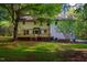 Expansive backyard with a well-maintained lawn, mature trees, and the back of the house with a deck at 15 Pine Ridge, Pittsboro, NC 27312