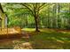 A view of the backyard with the wooden deck attached to the house looking out on the greenery at 15 Pine Ridge, Pittsboro, NC 27312