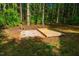 A view of the backyard with the wooden deck on a gravel and brick base at 15 Pine Ridge, Pittsboro, NC 27312