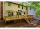 View of the backyard, the wooden deck, and stairs, plus partial view of the back of the house at 15 Pine Ridge, Pittsboro, NC 27312