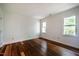 Sun-filled bedroom featuring a hardwood floor, base molding, and natural light at 15 Pine Ridge, Pittsboro, NC 27312