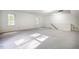 Bonus room with large windows, neutral carpet, and stairs with painted railing at 15 Pine Ridge, Pittsboro, NC 27312