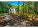 Exterior of a home with ample parking, surrounded by a lush, green forest at 15 Pine Ridge, Pittsboro, NC 27312