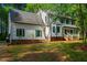 View of a home exterior with bay window and green shutters, nestled in a lush, wooded setting at 15 Pine Ridge, Pittsboro, NC 27312