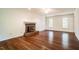 Large living room boasting gleaming hardwood floors and cozy fireplace with natural lighting at 15 Pine Ridge, Pittsboro, NC 27312