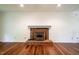 Spacious living room featuring hardwood floors and a brick fireplace with white mantle at 15 Pine Ridge, Pittsboro, NC 27312