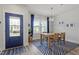 Bright dining room featuring a wooden table with seating, blue curtains, and a stylish pendant light at 1526 Millrock Trl, Wendell, NC 27591