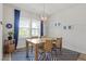Bright dining room with wooden table, wicker chairs, a modern light fixture, and a blue accent rug at 1526 Millrock Trl, Wendell, NC 27591