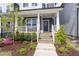 Inviting front porch with white railings, flower boxes, and a blue front door, complemented by professionally landscaped garden at 1526 Millrock Trl, Wendell, NC 27591