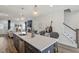 Modern kitchen featuring a large island with barstools, stainless steel dishwasher and a living room view at 1526 Millrock Trl, Wendell, NC 27591