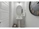 Stylish powder room features a pedestal sink, decorative mirror, and modern lighting at 1526 Millrock Trl, Wendell, NC 27591