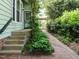 View of property side yard, brick path, and an abundant privacy hedge and landscaping at 1811 Park Dr, Raleigh, NC 27605