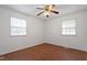 Inviting bedroom featuring wood floors, ceiling fan and two large windows at 1813 Grady Dr, Durham, NC 27712