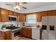 Efficient kitchen with stainless steel appliances, wooden cabinets, and ample counter space with natural light at 1813 Grady Dr, Durham, NC 27712