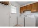 Laundry room with washer, dryer, upper cabinets, a window, and an exterior door at 1813 Grady Dr, Durham, NC 27712