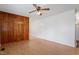 Open living room with wood flooring, half wood paneling, neutral walls and a ceiling fan at 1813 Grady Dr, Durham, NC 27712