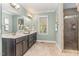 Bathroom with double vanity, tiled shower, tile floors, and natural light at 2000 Monthaven Dr, Wake Forest, NC 27587
