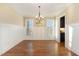 Dining room with hardwood floors, wainscoting detail, modern chandelier, and neutral paint at 2000 Monthaven Dr, Wake Forest, NC 27587