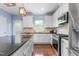 Bright kitchen featuring white cabinets, granite countertops, and stainless steel appliances at 214 S Camellia St, Chapel Hill, NC 27516