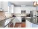 Well-lit kitchen with white cabinetry, stainless steel appliances, granite counters, and hardwood flooring at 214 S Camellia St, Chapel Hill, NC 27516