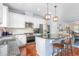 Bright kitchen featuring a granite island, wooden barstools, and pendant lighting at 214 S Camellia St, Chapel Hill, NC 27516