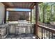 Outdoor kitchen with stone accents, complete with a built-in grill and stainless steel appliances at 216 Bella Rose Dr, Chapel Hill, NC 27517