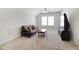 Open living room with a brown futon, ceiling fan, and a large window providing natural light at 216 Bella Rose Dr, Chapel Hill, NC 27517
