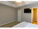 Cozy bedroom with a tray ceiling, a wall-mounted TV, and neutral-colored walls at 216 Harvester Dr, Holly Springs, NC 27540