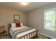 Comfortable bedroom featuring a queen-sized bed with a colorful blanket and a sunny window at 216 Harvester Dr, Holly Springs, NC 27540