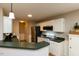Bright kitchen showcasing white cabinets, dark countertops, and stainless steel appliances at 216 Harvester Dr, Holly Springs, NC 27540