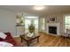 Open living room showcasing a fireplace, hardwood floors, and seamless flow into the dining area at 216 Harvester Dr, Holly Springs, NC 27540