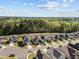 An aerial view of a neighborhood shows modern homes surrounded by lush greenery and trees at 218 Maple Walk St, Durham, NC 27703