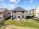 A manicured backyard features a patio with seating, a grill, and a neatly maintained lawn at 218 Maple Walk St, Durham, NC 27703