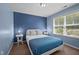 Cozy bedroom with blue walls, comfortable bed, and bright natural light from window at 218 Maple Walk St, Durham, NC 27703