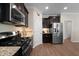 Well-equipped kitchen features granite countertops, stainless steel appliances and dark cabinets at 218 Maple Walk St, Durham, NC 27703