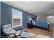 Inviting main bedroom showcasing a blue accent wall, plush carpet, and a cozy seating area at 218 Maple Walk St, Durham, NC 27703